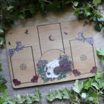 Tarot spread board with a cat skull surrounded by flowers and Ivy leaves, engraved wood