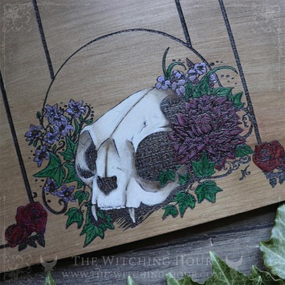 Tarot spread board with a cat skull surrounded by flowers and Ivy leaves, engraved wood