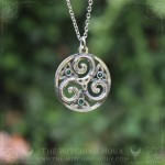 Triskel pendant in a circle, adorned with triquetra and small crystals, celtic and irish jewelry