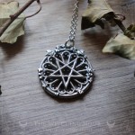 Gothic pentagram necklace on a cathedral rose window, occult jewelry