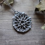 Pendentif pentacle inversé sur rosace de cathédrale gothique, bijou ésotérique artisanal