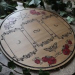 Wooden divination board decorated with red roses and a pentacle, for three-card tarot or oracle readings.