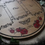 Wooden divination board decorated with red roses and a pentacle, for three-card tarot or oracle readings.