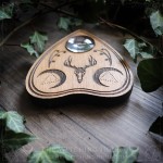 Wooden Ouija planchette decorated with a deer skull and crescent moons, curiosity cabinet decoration