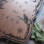 Wooden ouija board adorned with a pentagram in a triple moon, talking board and planchette, for spiritualism