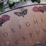 Wooden ouija board adorned with a pentagram in a triple moon, talking board and planchette, for spiritualism