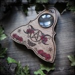 Wooden ouija board adorned with a pentagram in a triple moon, talking board and planchette, for spiritualism and divination