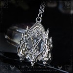 Sigil of Lucifer necklace in a gothic cathedral surrounded by two gargoyles